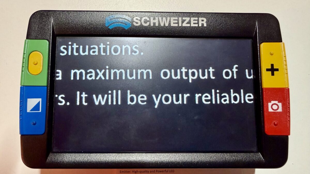 Das Bild zeigt die eingeschaltete Lupe. Auf dem Bildschirm ist zu lesen "...situations...a maximum output of...It will be your reliable..."