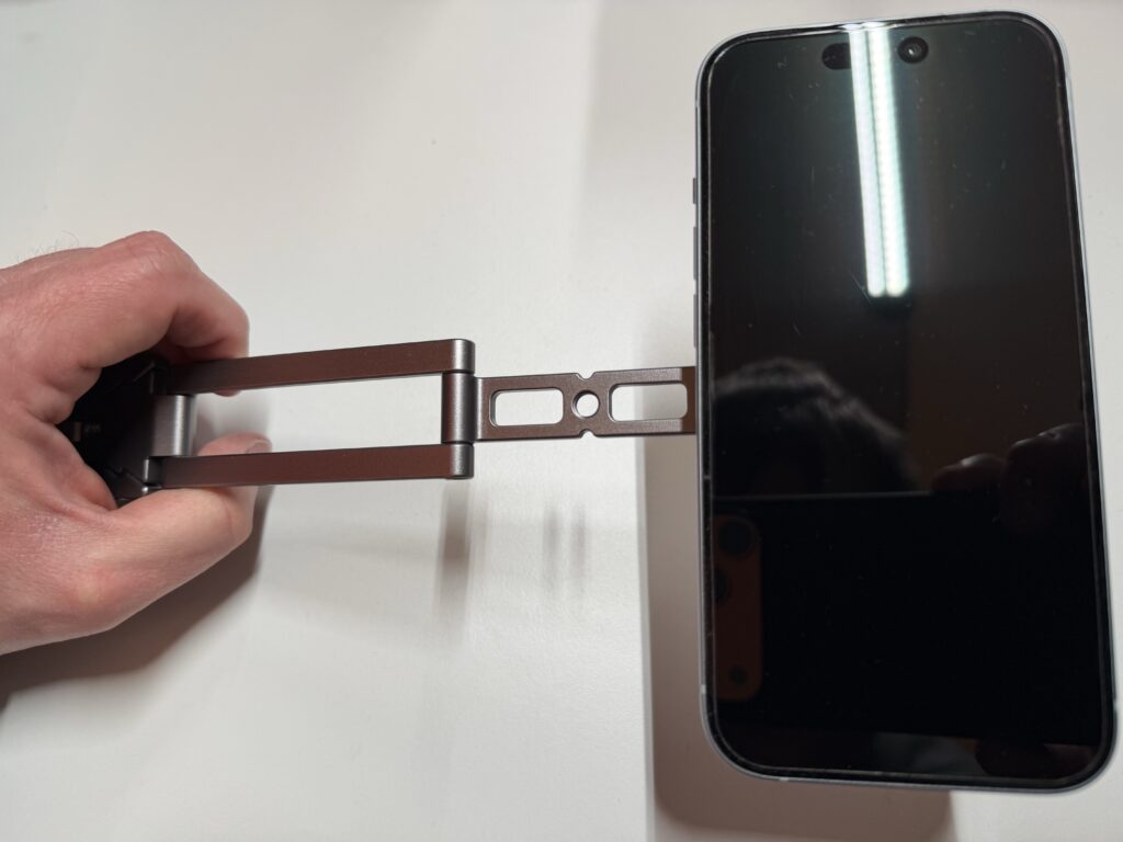 Das Bild zeigt das ausgefaltete Stativ, welches wie ein Selfie-Stick gehalten wird.